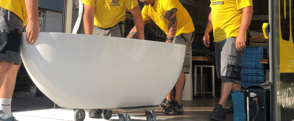 Jost Transport Mitarbeiter beim Zügeln einer Badenwanne. Spezialtransporte für Haushaltsgüter